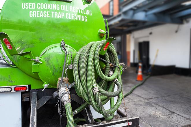 a professional technician pumping a restaurant's grease trap in Burlington MA